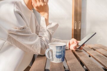 携帯を手に悩む女性